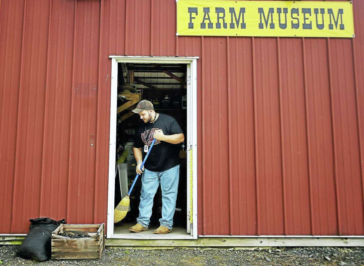 Durham resident and Durham Fair Farm Museum committee member Luciano Delmonte, 19, sweeps the floor Wednesday, “tidying up before we open,” he said. Fairgoers Sunday can watch the first-ever wedding at the fair.