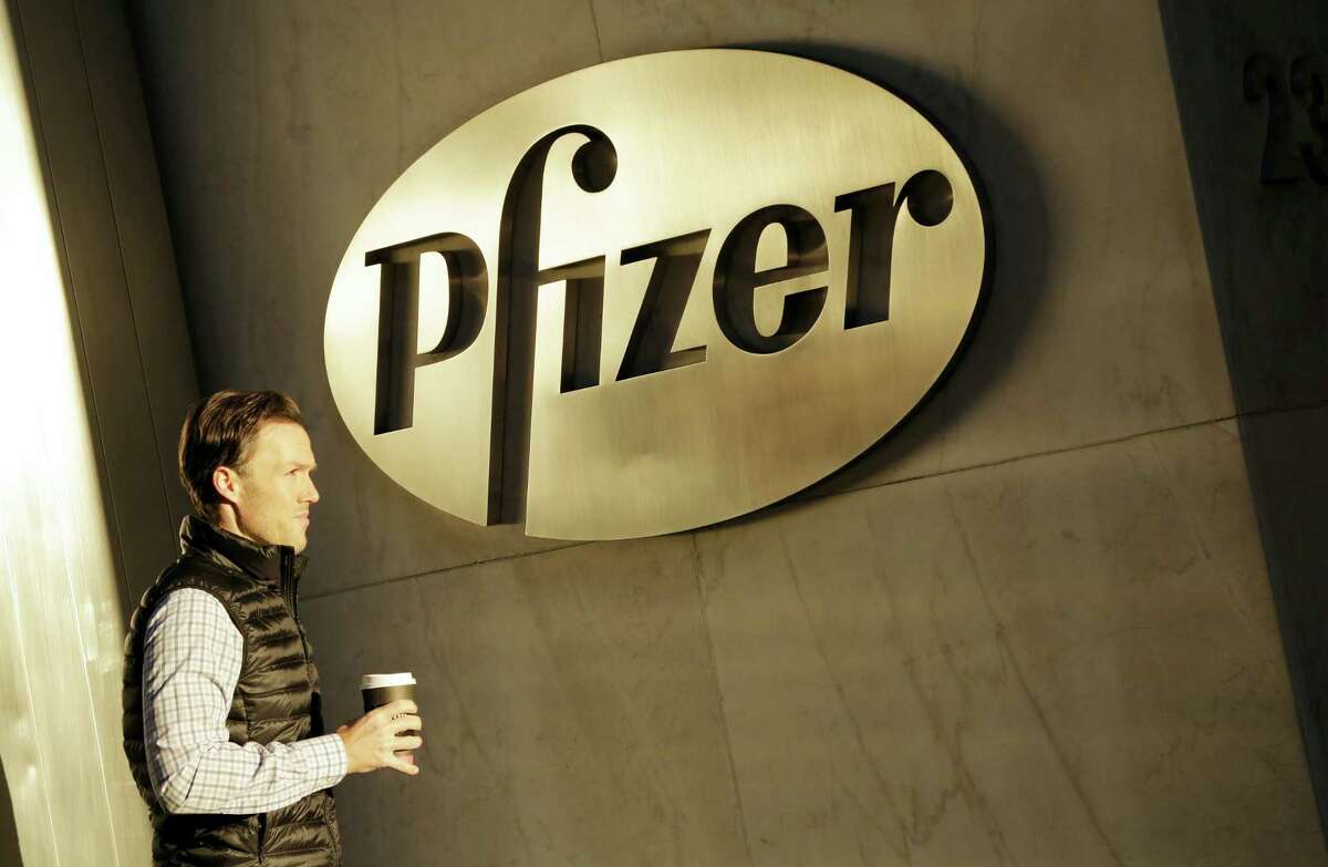 In this Monday, Nov. 23, 2015 photo, a man enters Pfizer’s world headquarters, in New York. Pfizer is buying biopharmaceutical company Medivation in a deal valued at about $14 billion.