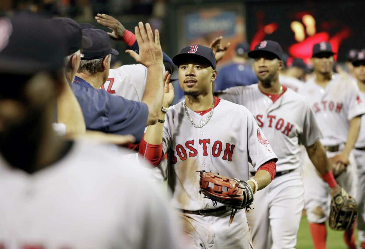 Boston Red Sox right fielder Mookie Betts high-fives teammates after a baseball game against the Baltimore Orioles in Baltimore Tuesday. Boston won 5-2 for its sixth straight victory.