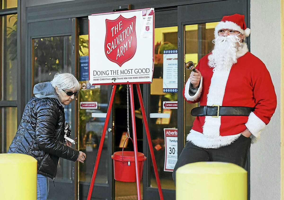 Catherine Avalone/New Haven Register Will Ruddell, son of New Haven Register reporter Pam McLoughlin helped spread holiday cheer as he volunteers last week for the Salvation Army Kettle Drive at Hobby Lobby in Milford. The Salvation Army is looking for volunteer bell ringers.