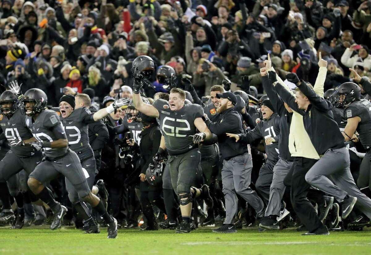 Army players and coaches run onto the field after beating Navy 21-17 in Baltimore on Saturday.