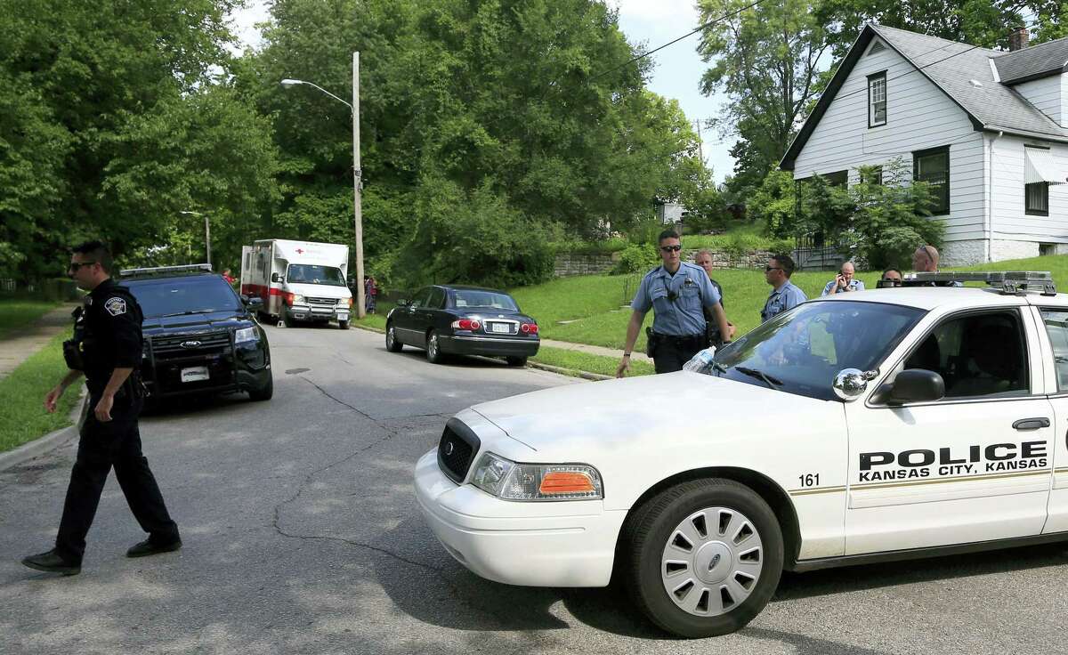 Kansas City, Kan., and Shawnee police officers work part of the shooting scene of a police officer in Kansas City, Kan. on Tuesday. A suspect in a drive-by shooting fatally shot Capt. Robert Melton, a 17-year veteran of the Kansas City, Kan. Police Department as the officer was sitting in his patrol car, police said.