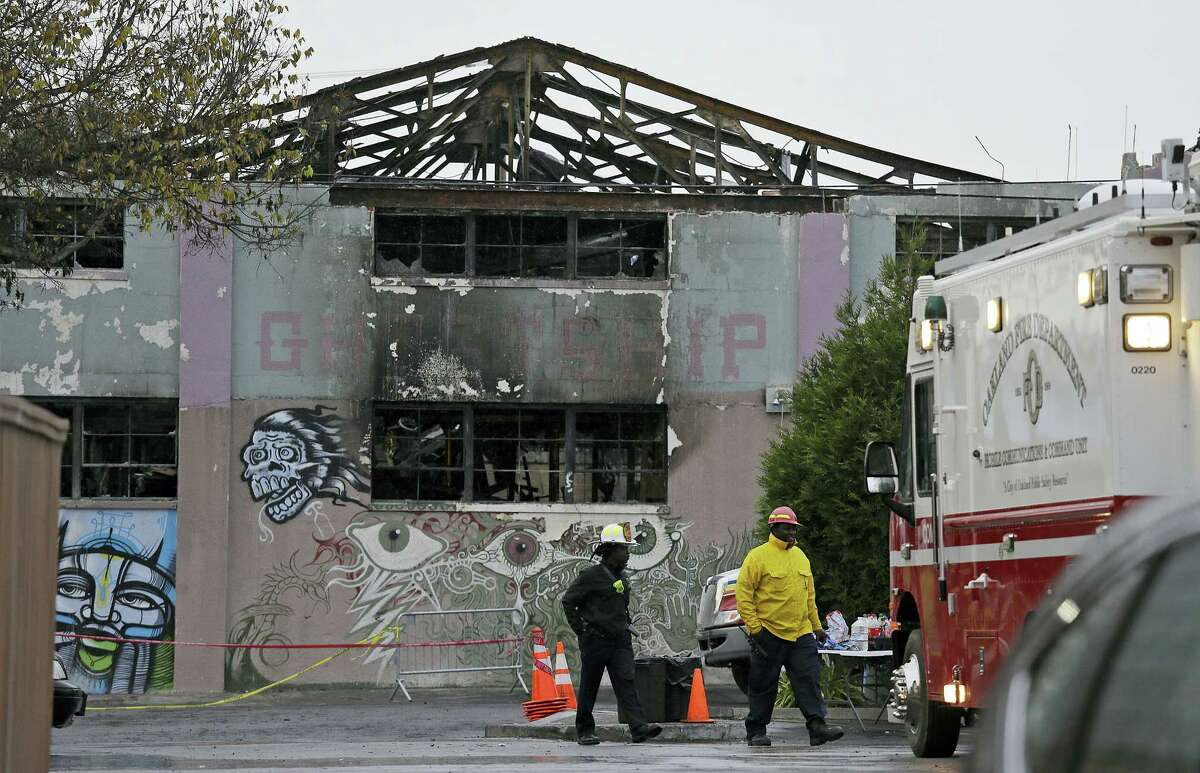 Oakland fire officials walk past the remains of the Ghost Ship warehouse damaged from a deadly fire in Oakland, Calif. The Dec. 2 fire killed dozens of people during a electronic dance party, after it raced through the building, trapping them inside. For those who survived, it was largely a matter of luck that when the first cries of “fire” were heard, they were able to find their way through smoke and darkness or were near enough to a door or already outside.