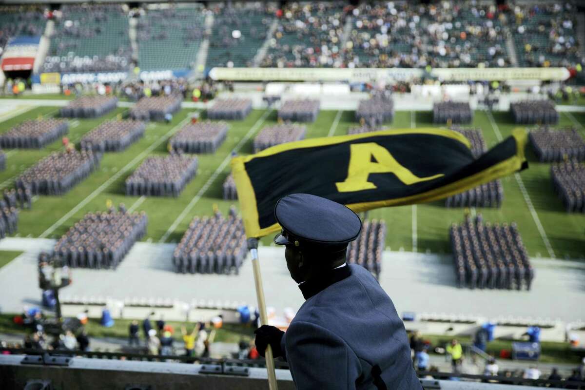 An Army Cadet signals Cadets as they march onto the field before a game against Navy in Philadelphia.