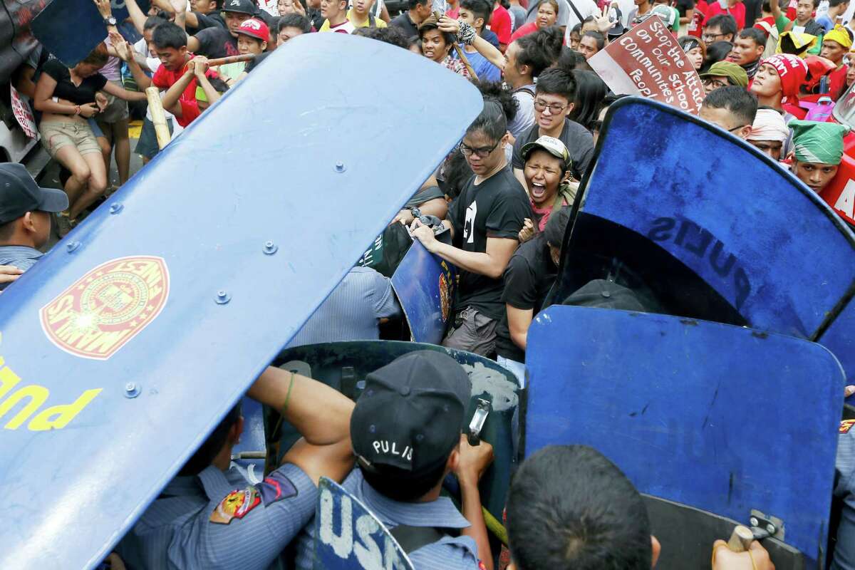 Police and protesters clash during a violent protest outside the U.S. Embassy in Manila, Philippines, Wednesday, Oct. 19, 2016. A Philippine police van rammed into protesters, leaving several bloodied, as an anti-U.S. rally turned violent Wednesday at the embassy in Manila.