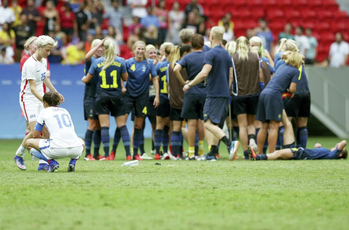 Megan Rapinoe and Carli Lloyd react as Sweden’s players celebrate after winning a quarterfinal match at the Olympics in Rio.