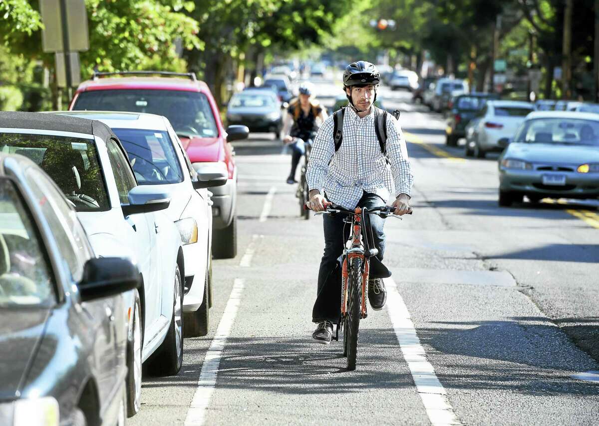 Bicyclists travel in the bicycle lane on Orange Street in New Haven in June.
