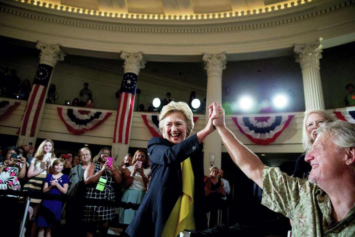 In this July 13, 2016 photo, Democratic presidential candidate Hillary Clinton high fives a member of the audience as she arrives to speak at the Old State House in Springfield, Ill. Clinton’s campaign is launching a major voter mobilization drive during the Republican National Convention, setting a national goal of getting more than 3 million people to register and commit to vote in the 2016 election.