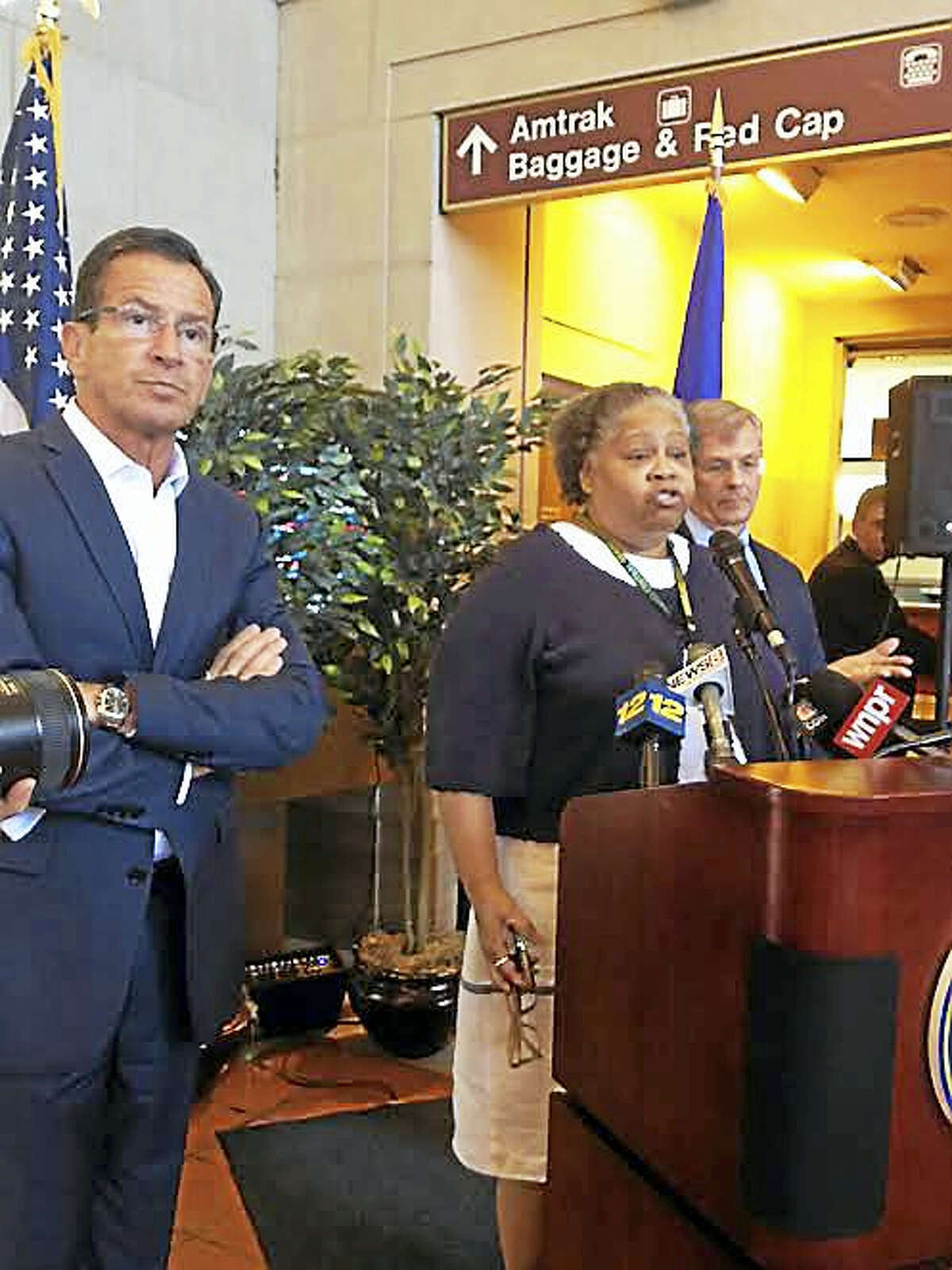 Gov. Dannel P. Malloy, left. Is joined by a Metro North employee and state Department of Transportation Commissioner James Redeker at Union Station in New Haven Thursday.