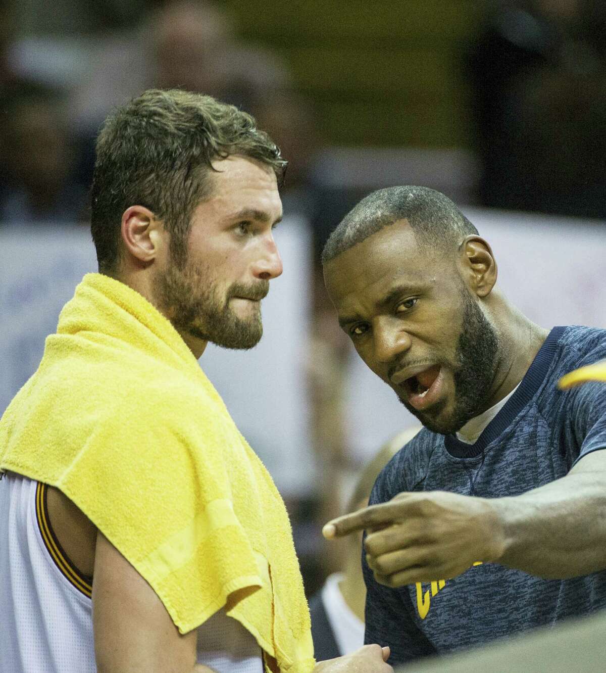 Cleveland Cavaliers’ Kevin Love (0) listens to LeBron James during a time out during the first half of an NBA preseason basketball game in Cleveland on Oct. 13, 2016.