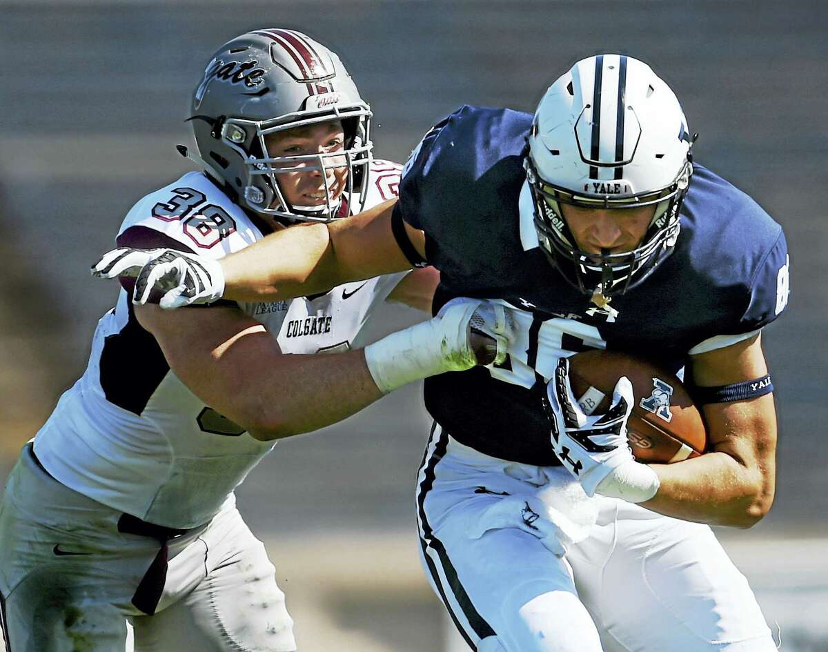 Yale tight end John Lager is tackled by Colgate’s Kyle Diener in a 55-13 victory for the Raiders in the season opener Saturday at the Yale Bowl in New Haven.