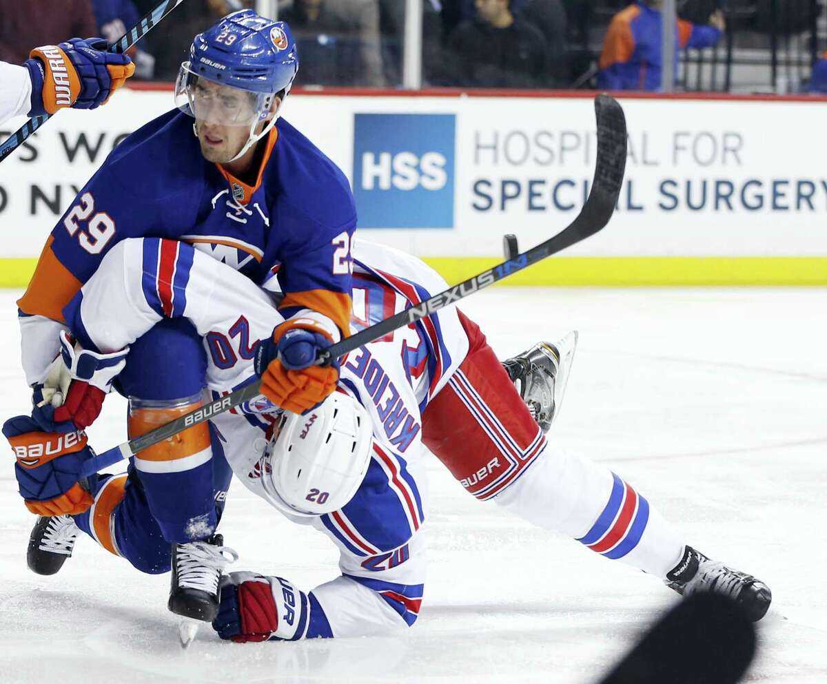 New York Islanders’ left wing Brock Nelson (29) trips New York Rangers’ left wing Chris Kreider (20) during the first period of the Islanders’ victory Tuesday night.
