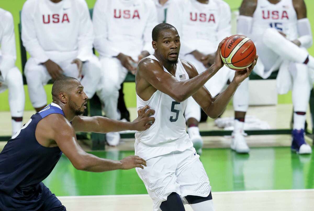 Kevin Durant (5) works the ball around France’s Boris Diaw, left, during Sunday’s game.