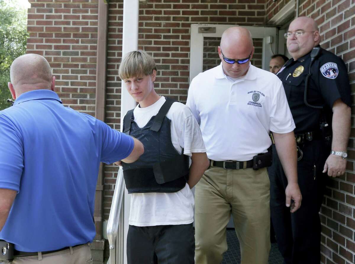 Charleston, S.C., shooting suspect Dylann Storm Roof, center, is escorted from the Sheby Police Department in Shelby, N.C. on June 18, 2015. Roof is a suspect in the shooting of several people Wednesday night at the historic The Emanuel African Methodist Episcopal Church in Charleston, S.C.