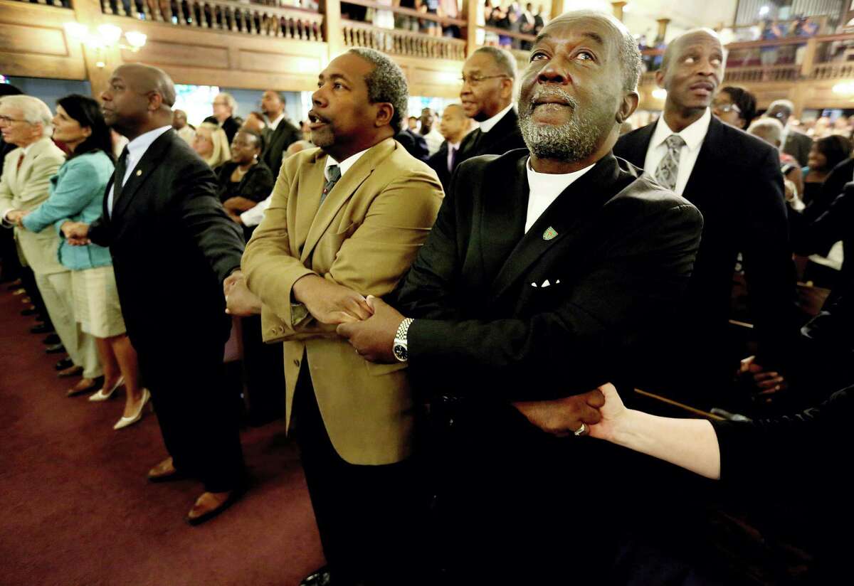 From left, Reverend Richard Harkness holds hands with Reverend Jack Lewin during a prayer vigil held at Morris Brown AME Church for the victims of Wednesday’s shooting at Emanuel AME Church on June 18, 2015 in Charleston, S.C. Dylann Storm Roof, 21, was arrested Thursday in the slayings of several people, including the pastor at a prayer meeting inside the historic black church.