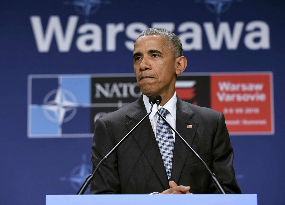 President Barack Obama pauses while speaking about the events in Dallas at the beginning of his news conference at PGE National Stadium in Warsaw, Poland, Saturday, July 9, 2016. Obama is in Warsaw attending the NATO Summit.