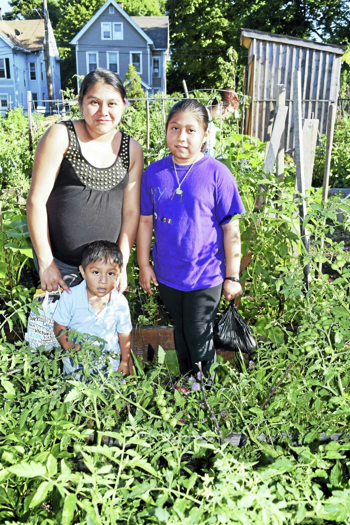 Rocio Rodriguez in her garden alongside her children Amy and Leonardo Rodriguez