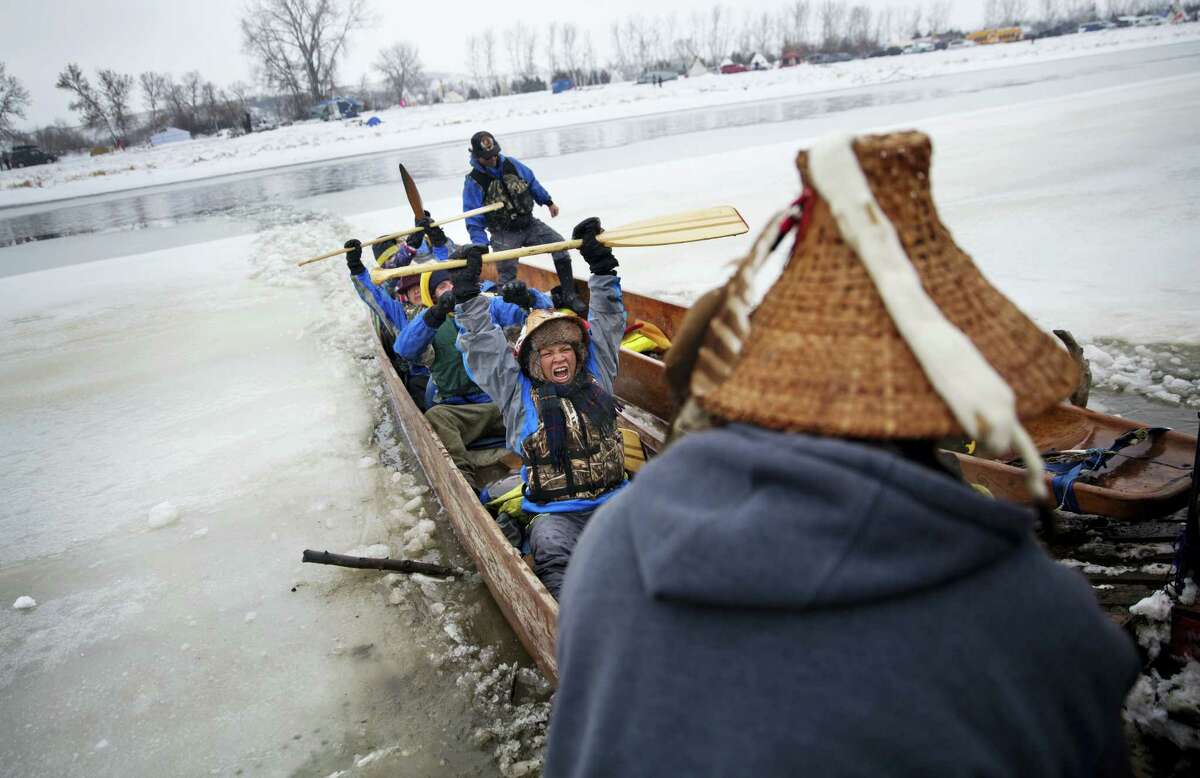In this Thursday, Dec. 1, 2016 photo, Virginia Redstar of Colville, Wash., and a member of the Colville Native American tribe, celebrates upon reaching shore by canoe at the Oceti Sakowin camp where people have gathered to protest the Dakota Access oil pipeline in Cannon Ball, N.D. Redstar traveled from Montana with fellow tribal members on canoe for 10 days down the Missouri river to reach the camp.