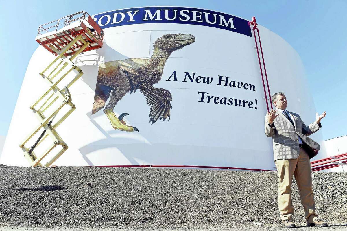 David Skelly, director of the Yale Peabody Museum of Natural History, speaks during a ceremony showcasing a mural of the dinosaur, Deinonychus, being installed on a heating oil tank at Magellan Midstream Partners Inc., at New Haven Harbor Tuesday.