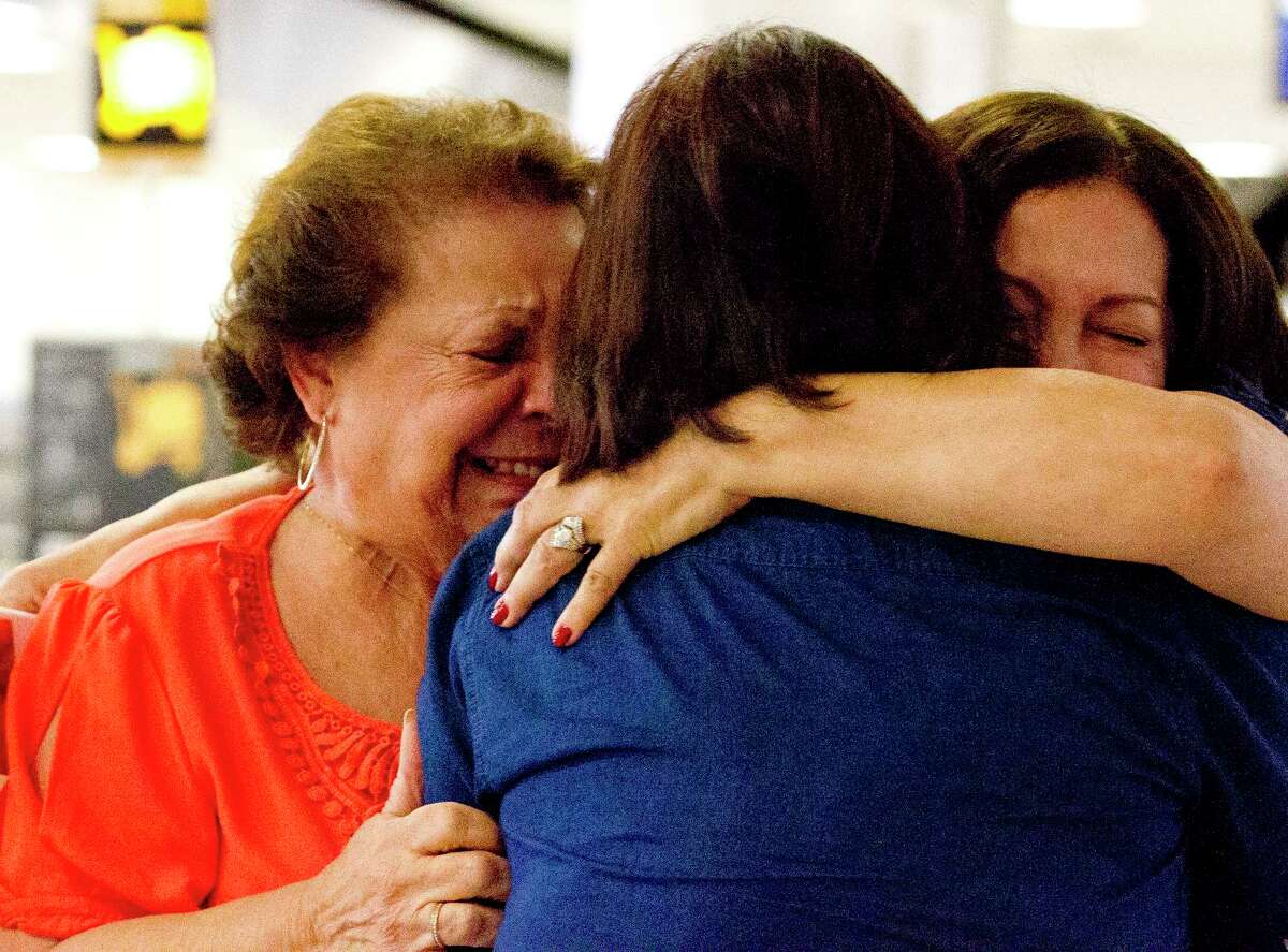 Jannett Balbas Eguchi, left, cries as she embraces Emily Balbas Lonsberry Cook and Rachel Meforana as the three sisters meet for the first time at Bush Intercontinental Airport, Thursday in Houston. Meforana, of Spring, was adopted when she was six months old in Manhattan and finally connected to long lost siblings from California she never knew about through ancestry.com this year.