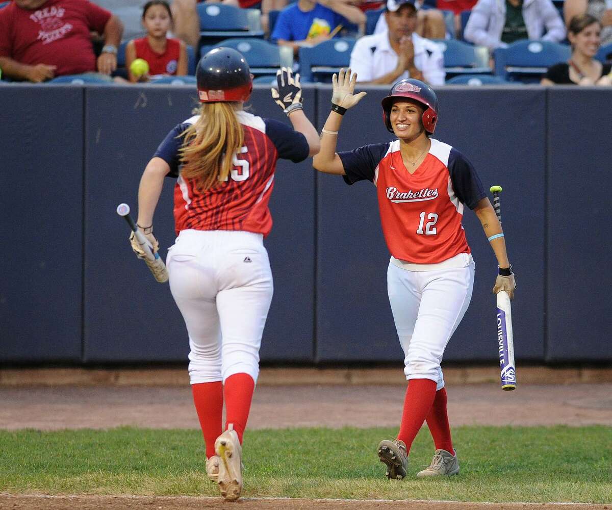 Stratford Brakettes players Megan Hodgton, left, and Gabby Laccona celebrate Hodgton’s run that broke a scoreless tie in the fifth inning of the annual Battle of the Sexes softball game against the Bridgeport Bluefish Sunday night at the Ballpark at Harbor Yard Ballpark in Bridgeport.