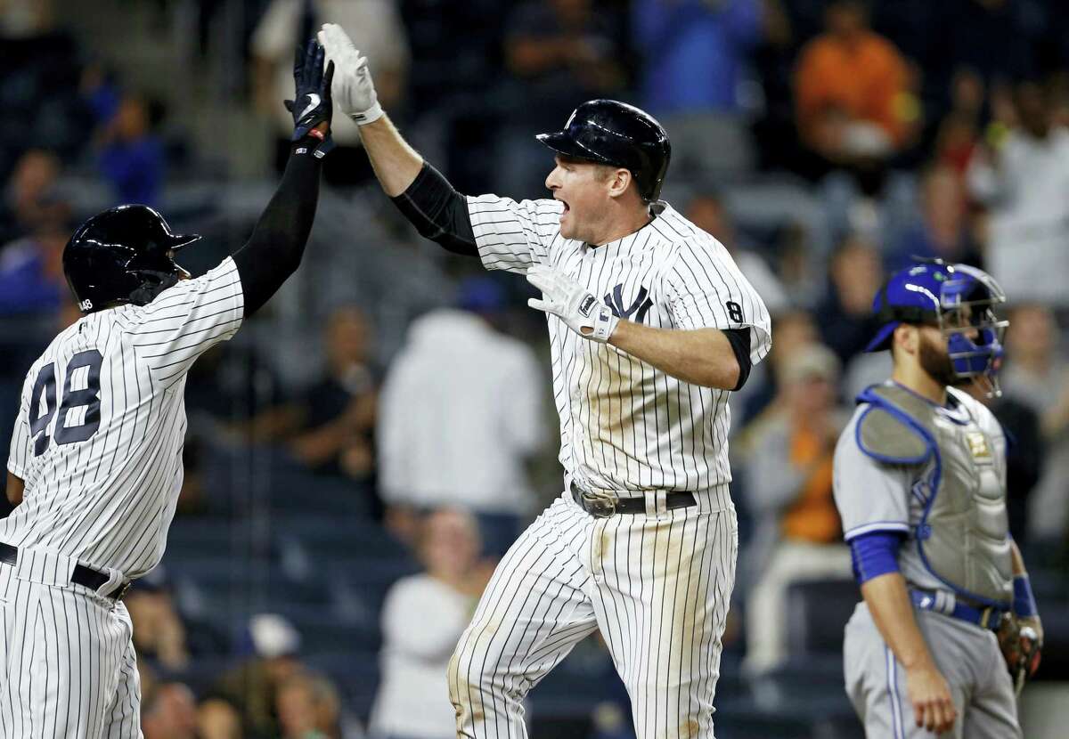 New York’S Chase Headley celebrates hitting a two-run home run with Eric Young Jr. (48) as Toronto catcher Russell Martin looks away during the eighth inning.