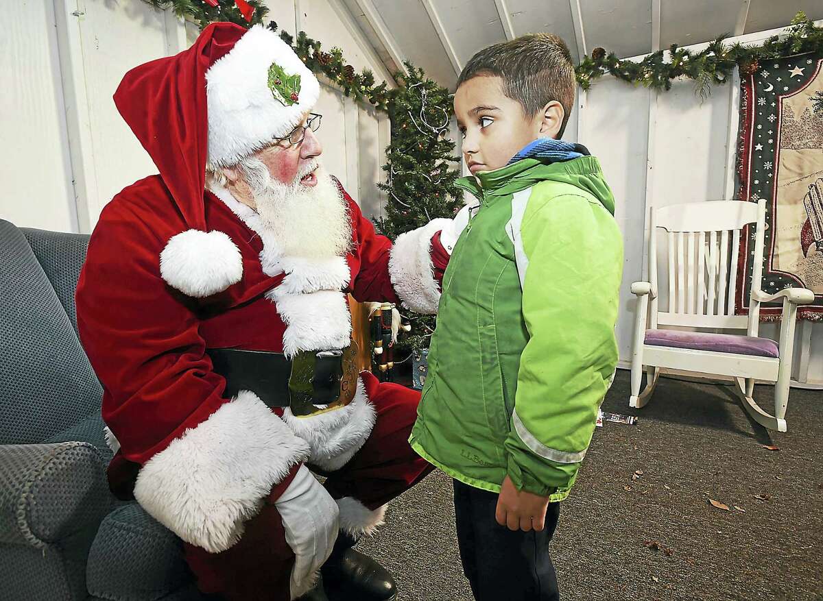 Santa asks Yariel Velazquez, 5, of New Haven what he has on his Christmas list at Thursday’s holiday kick-off event on the Green.