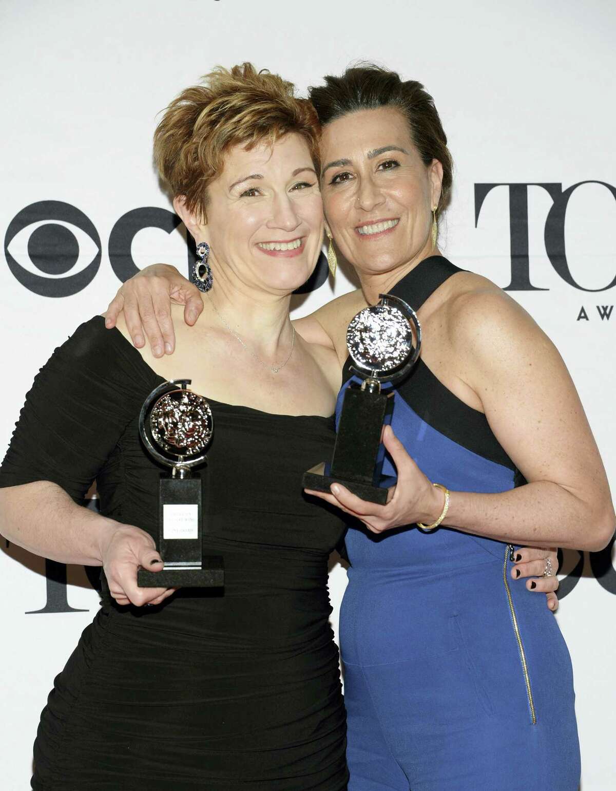 In this June 7, 2015 photo, Lisa Kron, left, and Jeanine Tesori pose with the award for best score for “Fun Home” in the press room at the 69th annual Tony Awards in New York. “Fun Home,” the 2015 Tony-winning best musical, has begun its national tour as the first Broadway show with a lesbian protagonist, one who is dealing with a parent’s suicide and her own sexuality.