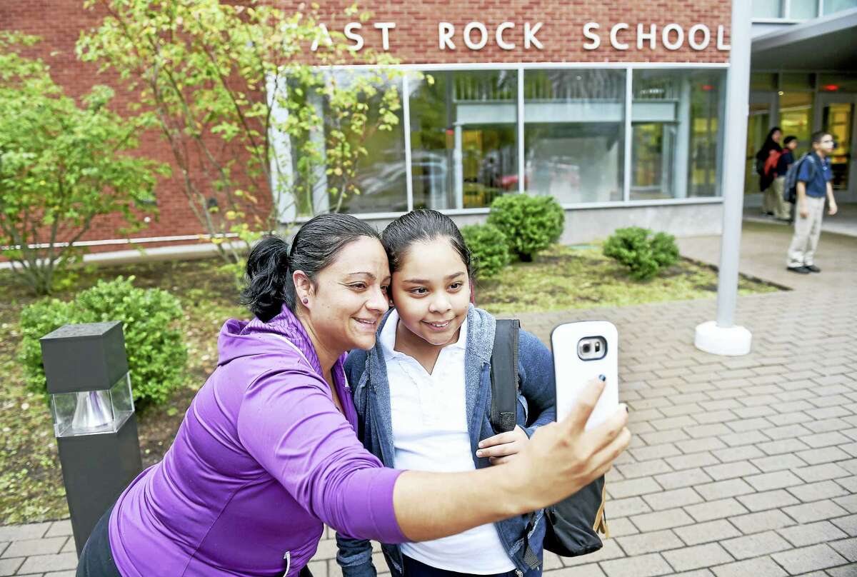 Luciana Clavero, left, takes a selfie with her daughter, Daphne Reyes, 10, in front of East Rock School in New Haven on the first day of school Thursday. Reyes is going into fourth grade.
