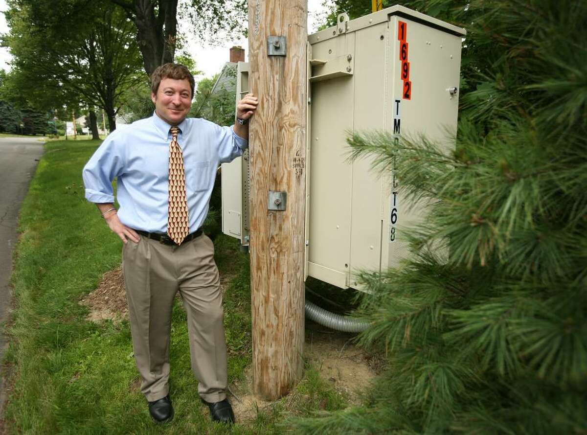 Al Dressler stands by the AT&T VRAD box near his home on Bailey Street in Trumbull. Dressler's complaint got the company to provide plants to help conceal the unit.