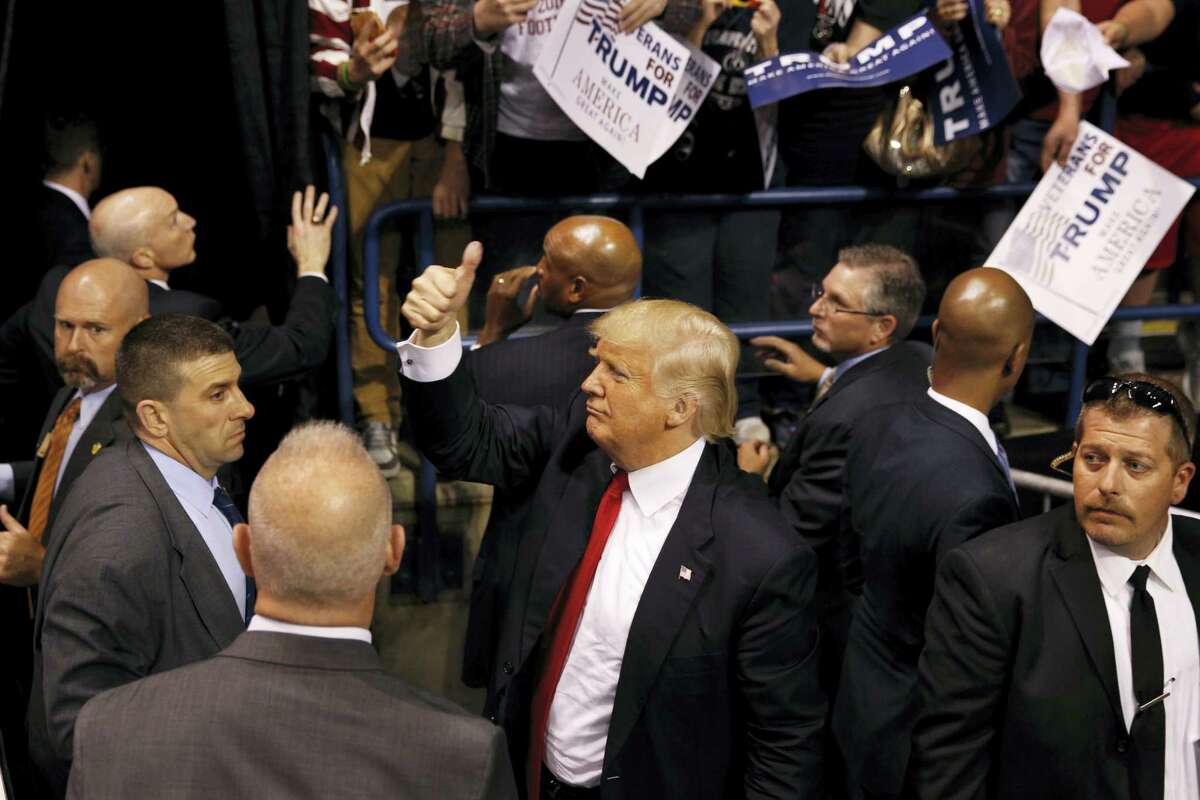 Security stands nearby as Republican presidential candidate, Donald Trump, center, gives a thumbs up to supporters after speaking at a campaign rally Monday, April 25, 2016, in Wilkes-Barre, Pa.