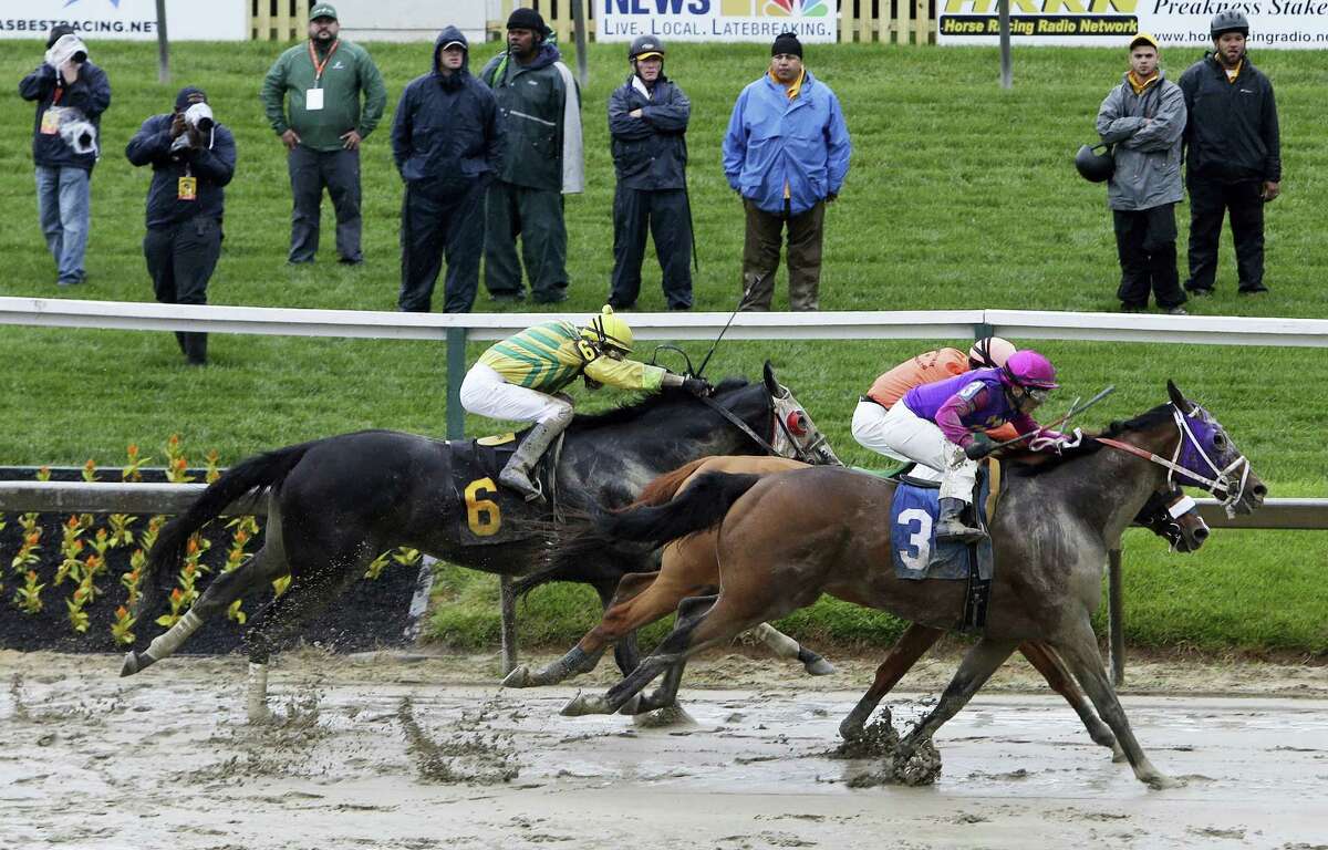Homeboykris (3), ridden by Horacio Karamanos, moves to the finish in the first race of the day on a muddy track ahead of the 141st Preakness Stakes horse race at Pimlico Race Course, Saturday, May 21, 2016, in Baltimore.