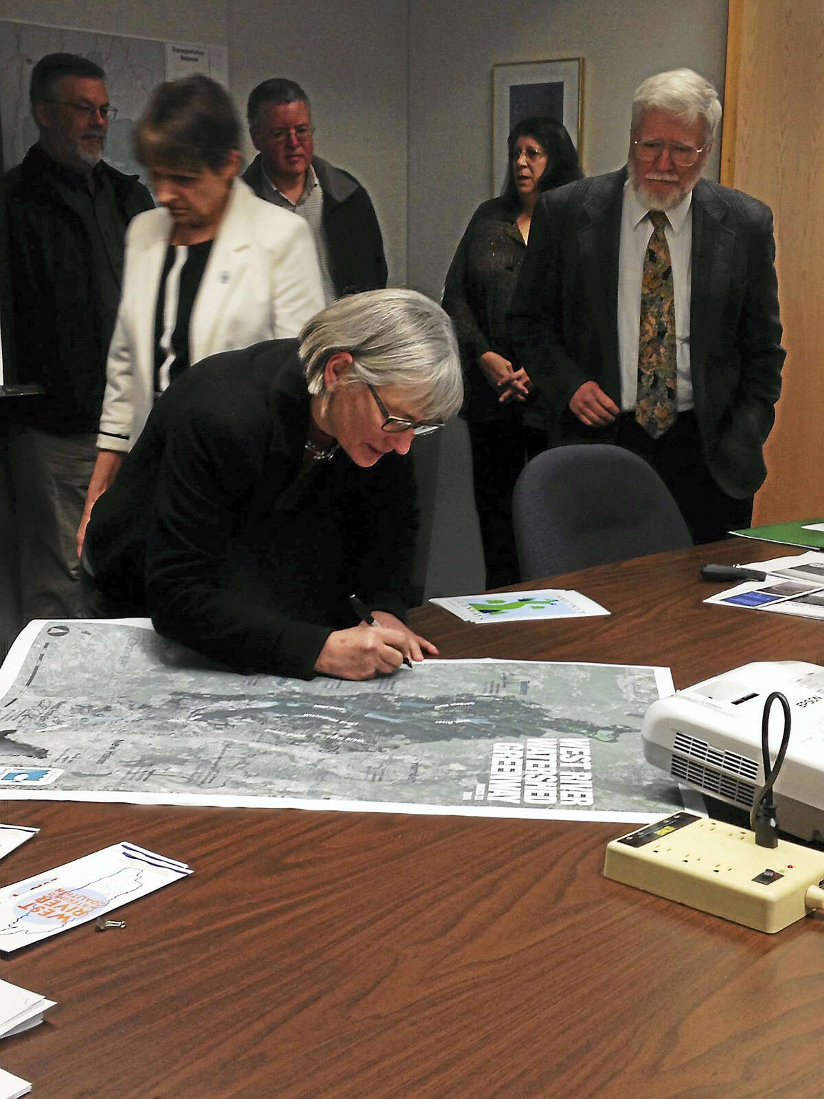 Martha Smith, a member of the steering commitee for the West River Watershed Coalition, signs the map of the newly-designated West River Watershed Greenway.