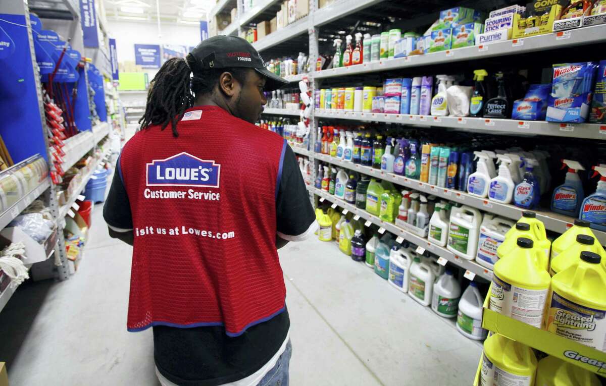 In this Nov. 14, 2011 photo, a Lowe’s employee walks down an aisle in the store in Saugus, Mass.
