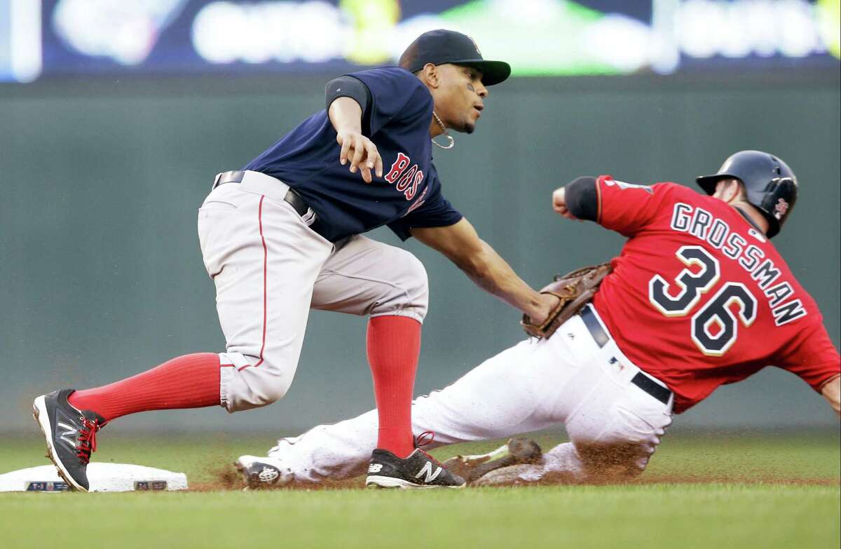 The Twins’ Robbie Grossman, right, is tagged out by Red Sox shortstop Xander Bogaerts on a steal attempt on Friday.