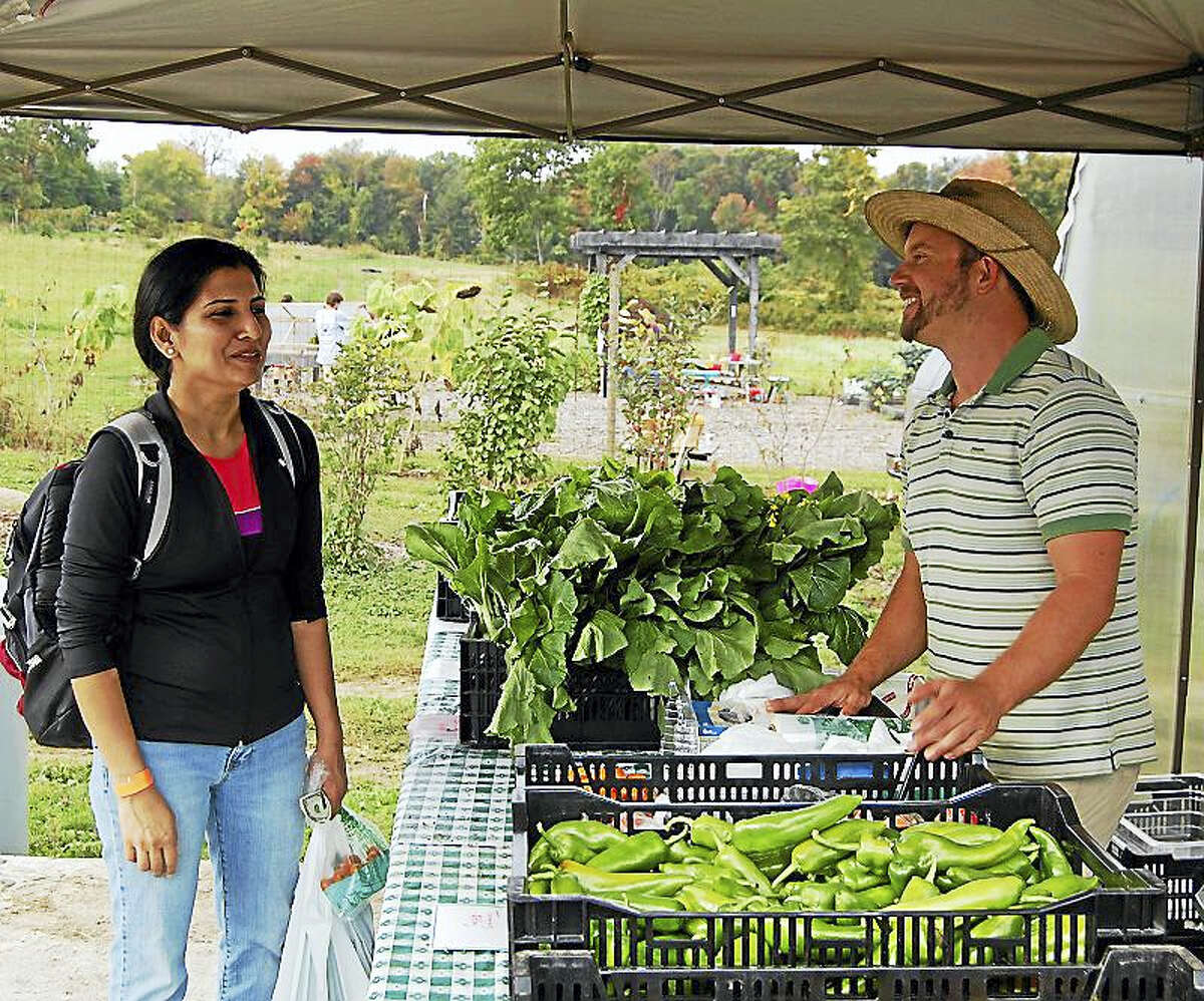 Steve Munno, know as “Farmer Steve” at Massaro Community Farm in Woodbridge, talks to a customer who’s buying produce during the farm’s annual Family Fun Day.