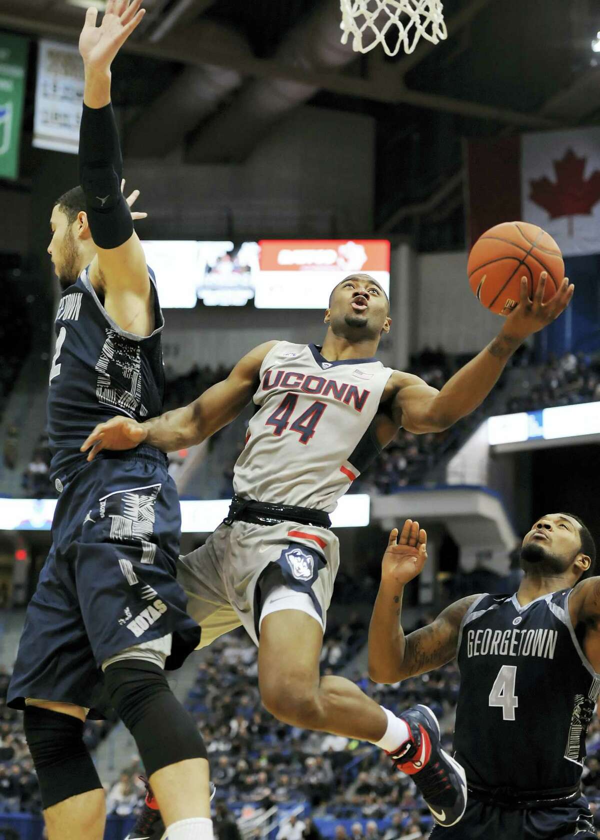 UConn’s Rodney Purvis shoots between Georgetown’s Bradley Hayes, left, and D’Vauntes Smith-Rivera, right, in the first half Saturday in Hartford.