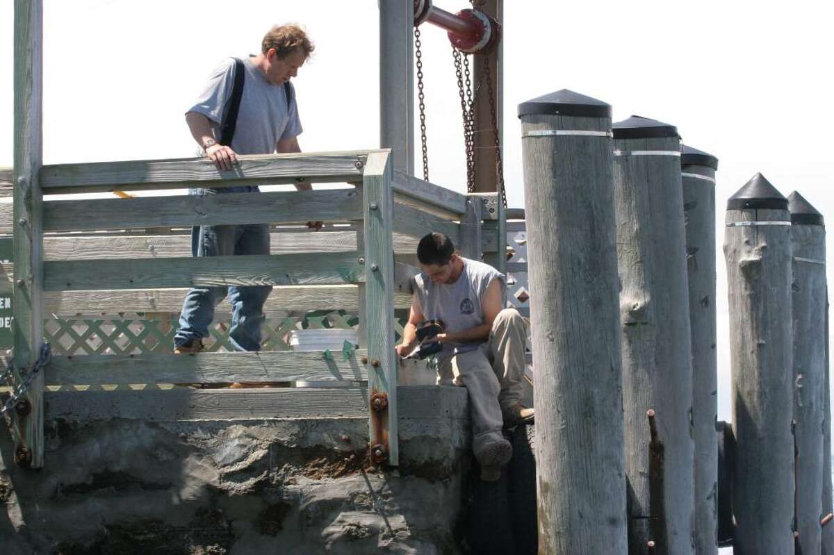 Greenwich Parks Department employees work on the pier at Island Beach in preparation for Saturday's start of seasonal ferry service.