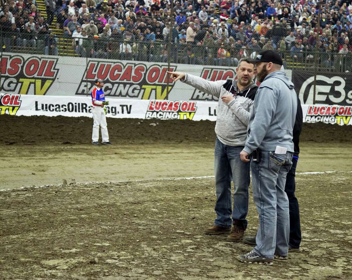 In this photo from Wednesday, NASCAR driver Tony Stewart gestures while talking about the track with Brad Chandler during Chili Bowl midget races at Tulsa’s Expo Square in Tulsa, Okla. Police are investigating after an off-duty officer heckled Stewart and was confronted by the driver on Friday.