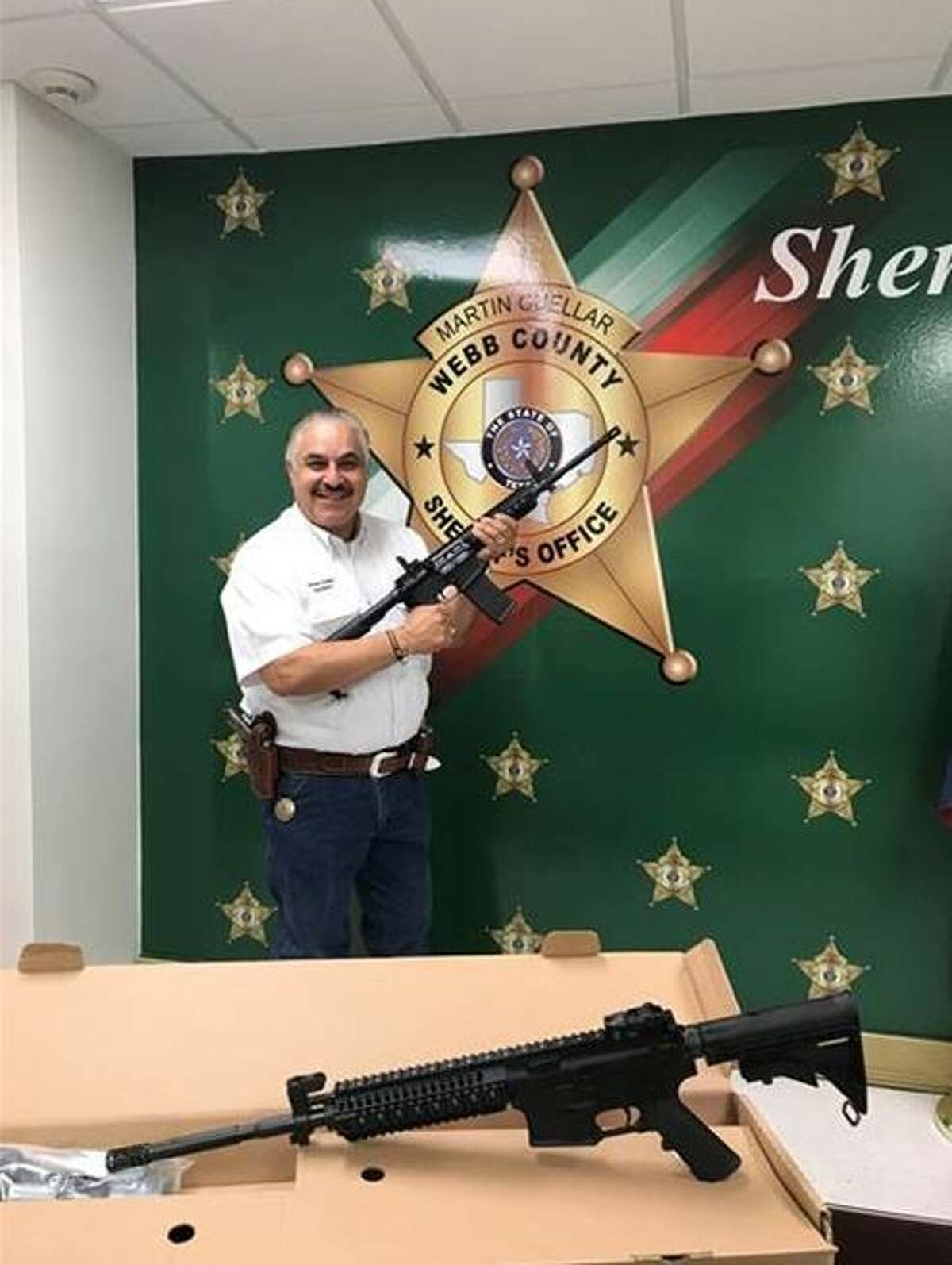 Sheriff Martin Cuellar poses with two rifles awarded by the NRA to the Webb County Sheriff’s Office.