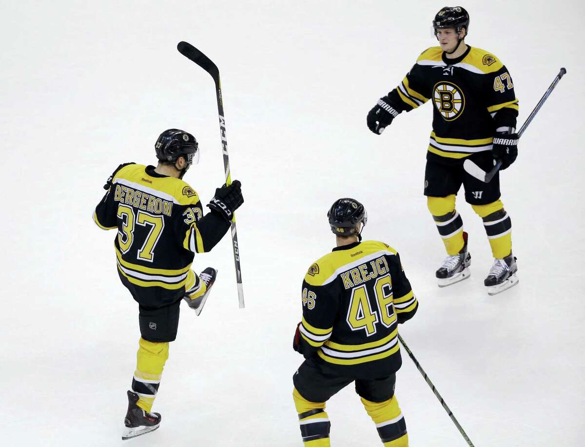 Bruins center Patrice Bergeron (37) celebrates his go-ahead goal with teammates David Krejci (46) and Torey Krug (47) in the third period Tuesday.