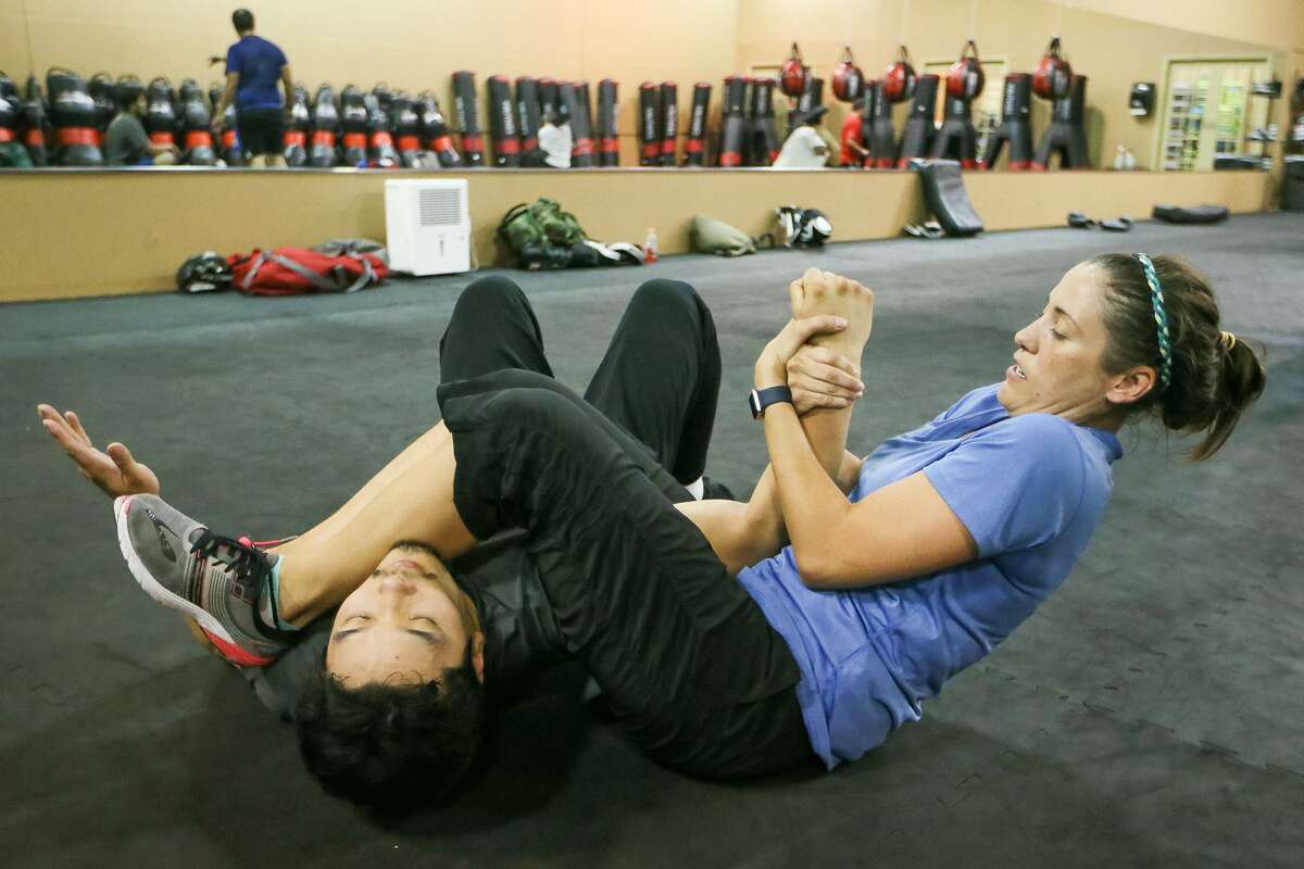 Meagan Harvey (right) pins an attacker, Nicholas West-Miles, after escaping from a choke hold during a KM 2/3 martial arts class at Krav Maga on July 14, 2017.