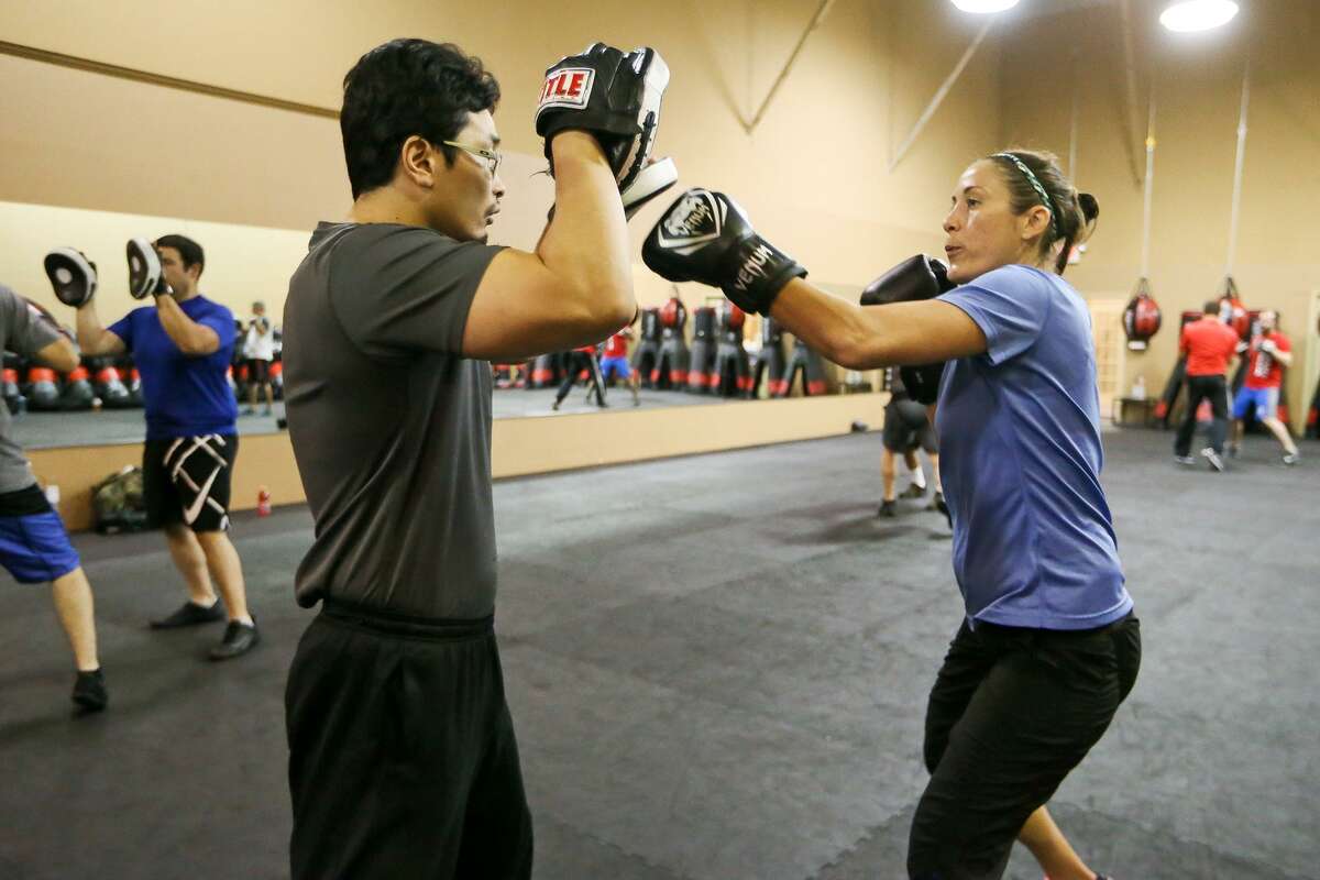 Meagan Harvey (right) does focus mitt work with Nicholas West-Miles during a KM 2/3 martial arts class at Krav Maga, 18450 Blanco Road, on July 14, 2017.