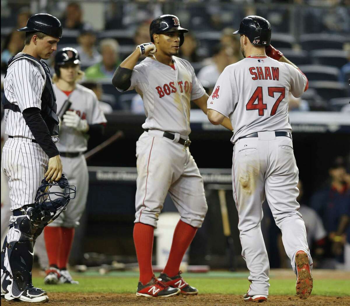 Yankees catcher John Ryan Murphy reacts as Xander Bogaerts, center, greets Red Sox’s Travis Shaw (47) after scoring on Shaw’s sixth-inning, two-run home run.