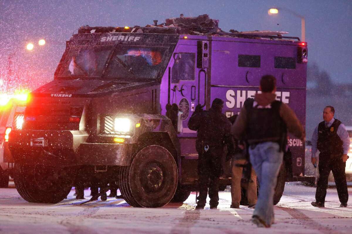 A police vehicle carries a suspect away from the intersection of Centennial and Fillmore after a shooting at a Planned Parenthood clinic Friday, Nov. 27, 2015, in Colorado Springs, Colo.