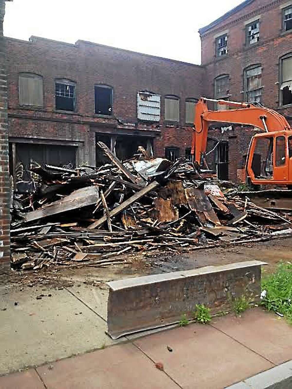 A wooden portion of building at 142 River St. was demolished Friday after small fire.