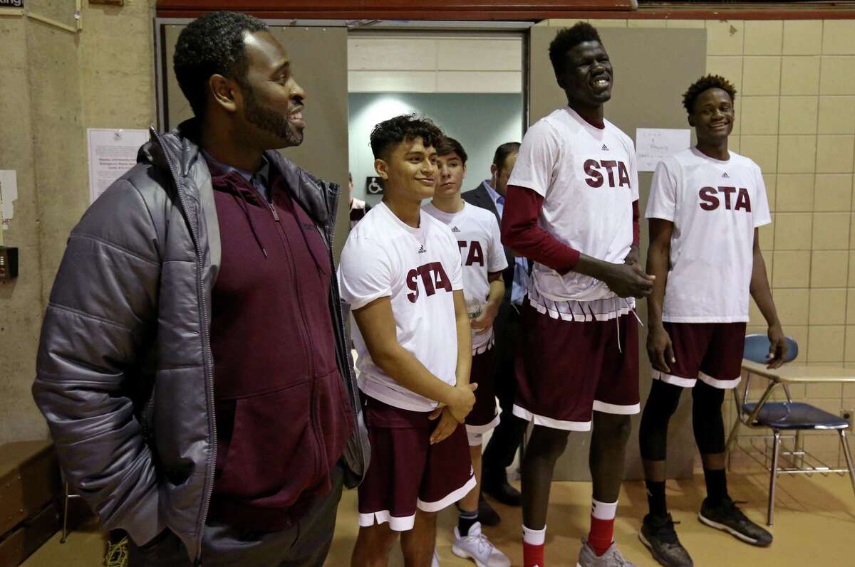 St. Anthony assistant coach Hennssy Auriantal (from left) talks with players Jay Ortiz, Quinton Uribe, Ousmane Ndim and Obi Prosper before the game with Virginia Episcopal School at the Nassau Community College gym in Garden City, N.Y.