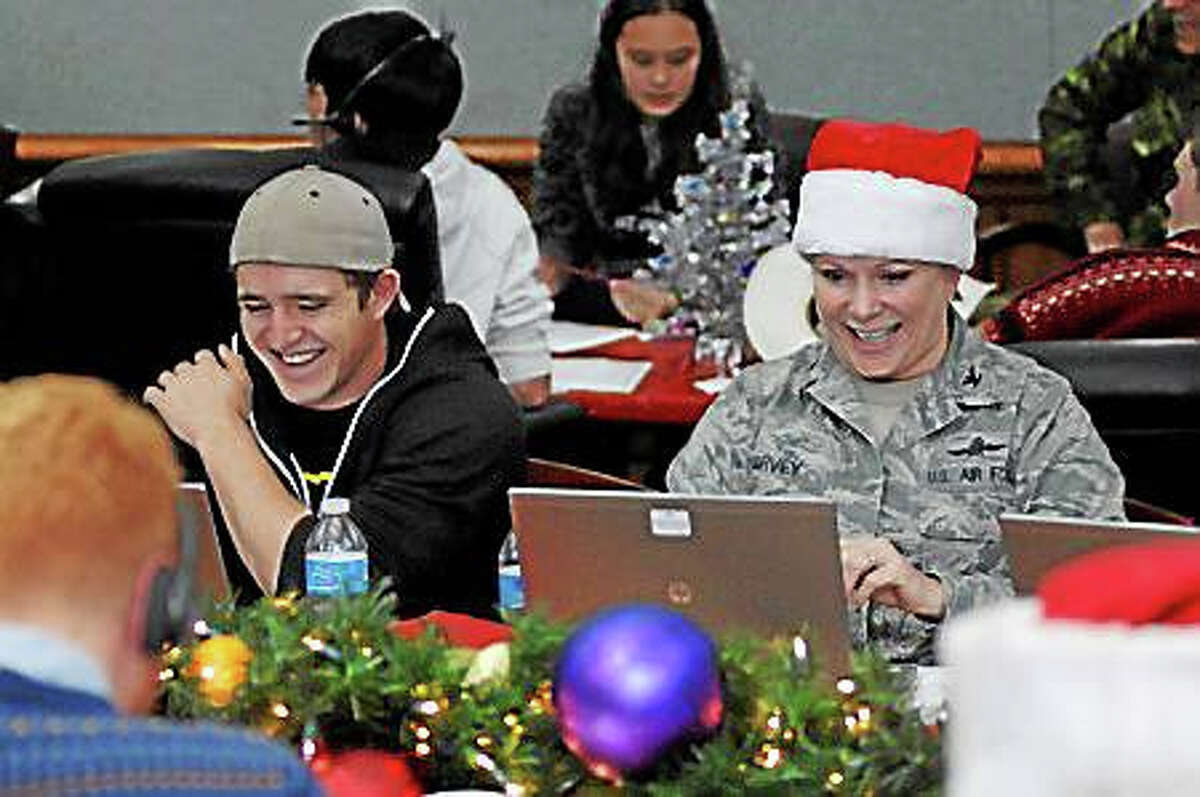 Volunteer tracker Matthew Harvey joined his mother Col. Tina Harvey to help answer emails from children and parents across the globe while at the NORAD Tracks Santa Operations Center on Peterson Air Force Base, Colorado Dec. 24, 2014. Photo by Air Force Master Sgt. Chuck Marsh