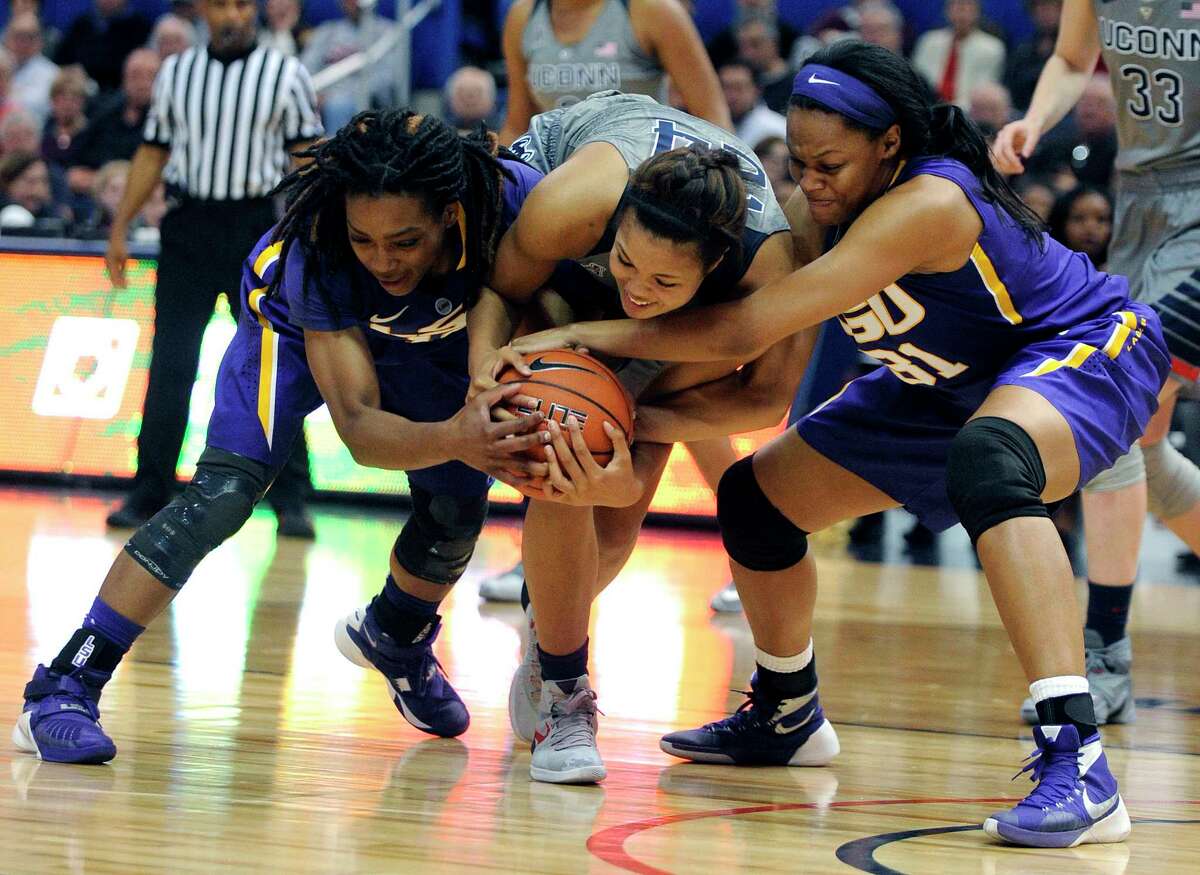LSU’s Jasmine Rhodes, left, and Ann Jones, right fight for a loose ball with Connecticut’s Napheesa Collier (24) during the first half on Monday.