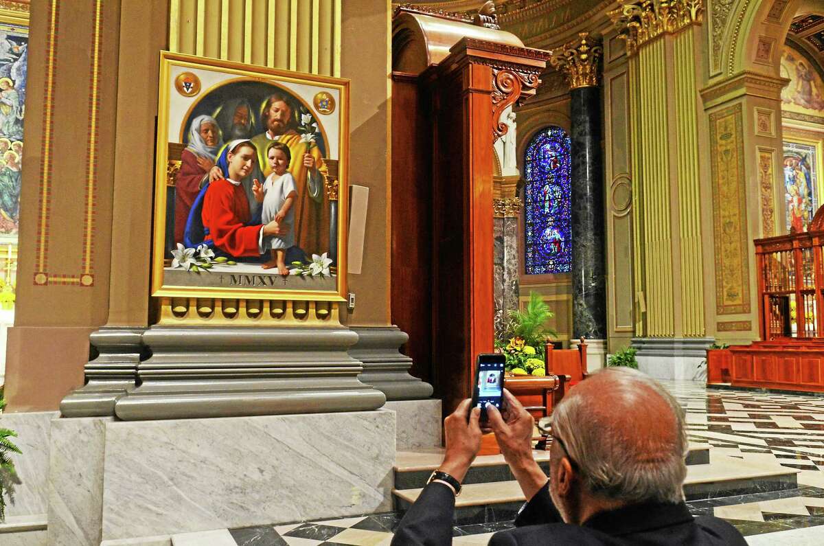 A man photographs the painting “The Holy Family” at Cathedral Basilica of Saints Peter and Paul in Philadelphia, Tuesday, September 22, 2015.